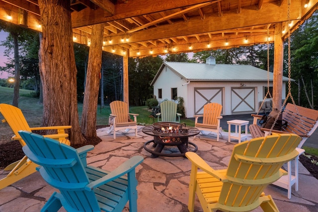 patio terrace at dusk with a storage unit and an outdoor fire pit