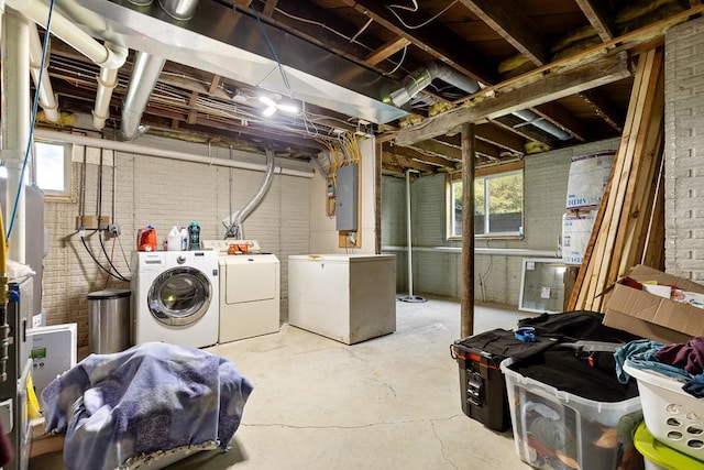 basement featuring washer and clothes dryer, refrigerator, and plenty of natural light