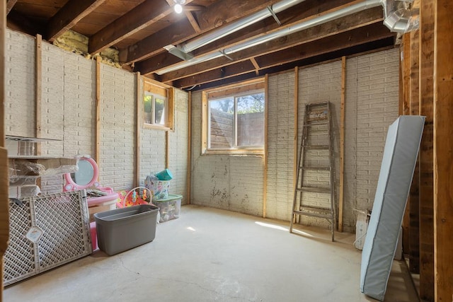 miscellaneous room featuring brick wall and concrete flooring