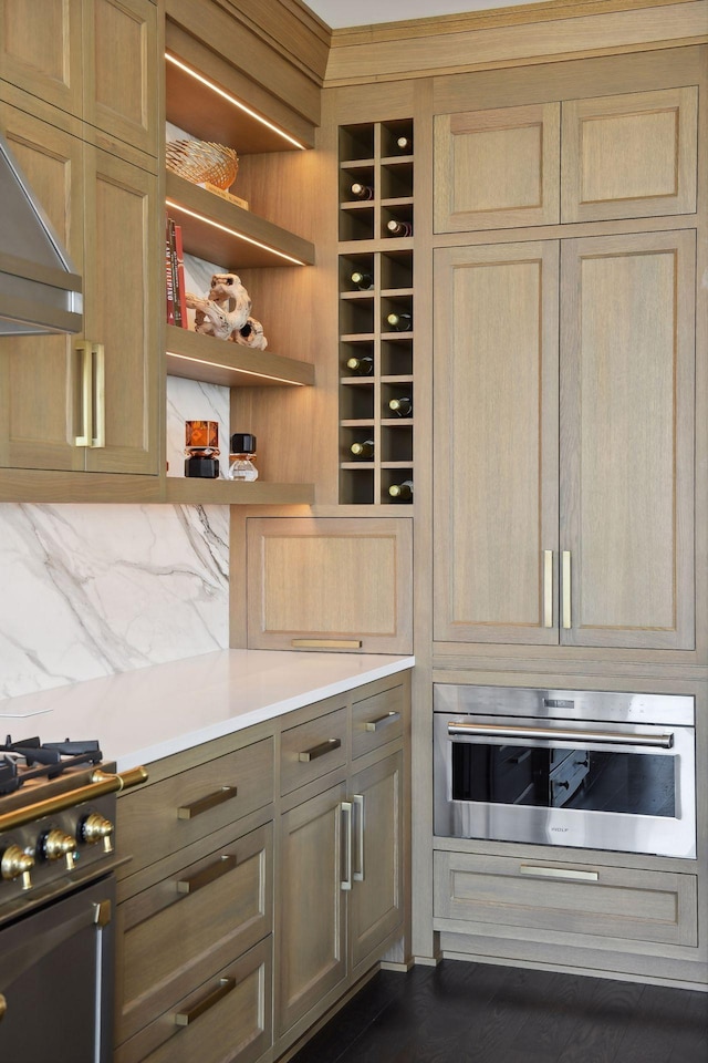 kitchen with oven, light brown cabinetry, black gas range, and exhaust hood