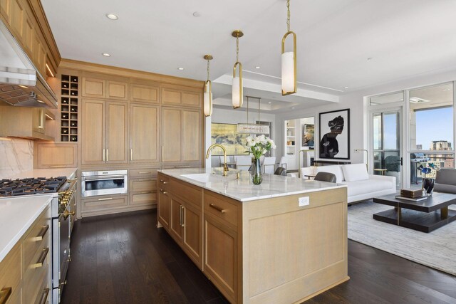 kitchen featuring custom exhaust hood, a kitchen island with sink, hanging light fixtures, sink, and appliances with stainless steel finishes