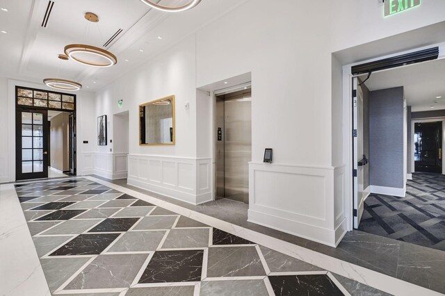 hallway featuring a high ceiling and elevator