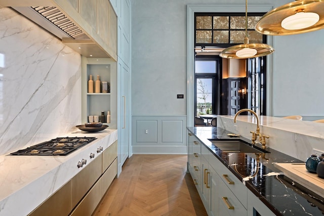 kitchen featuring gray cabinetry, sink, dark stone countertops, light parquet floors, and decorative light fixtures