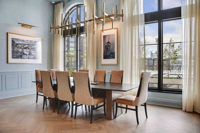 dining room featuring parquet floors and a high ceiling