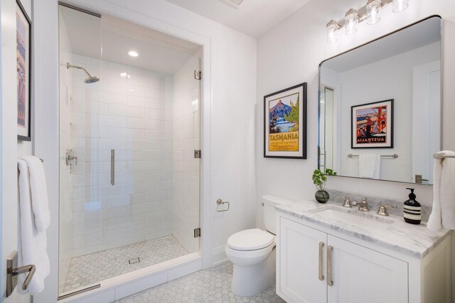 bathroom featuring vanity, toilet, and a shower with door