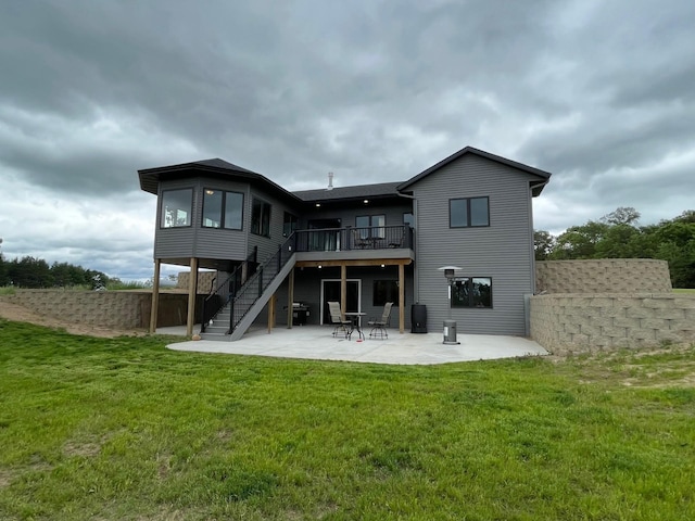 rear view of property featuring a yard, a patio, and a wooden deck