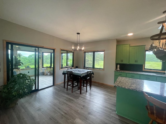 dining area with wood-type flooring and a notable chandelier