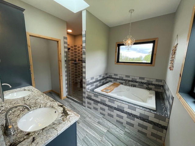 bathroom featuring a skylight, vanity, and shower with separate bathtub