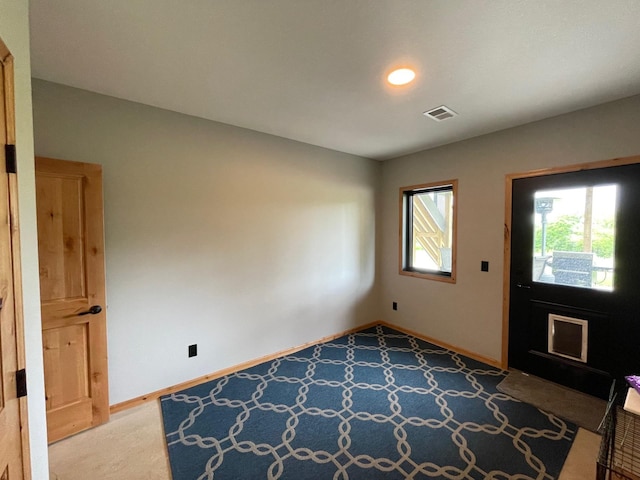 view of carpeted foyer entrance