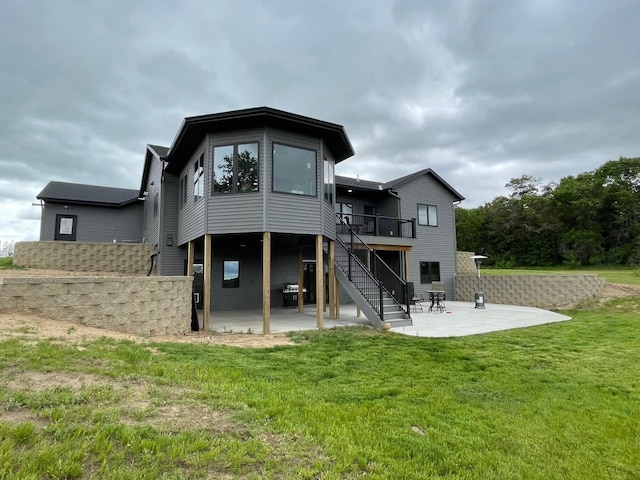 rear view of house featuring a lawn, a deck, and a patio