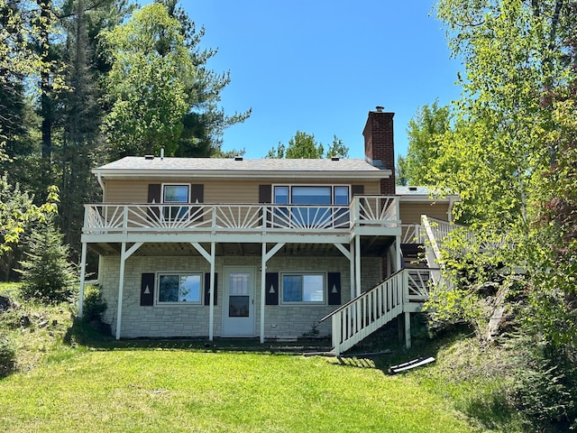 rear view of house with a lawn and a deck