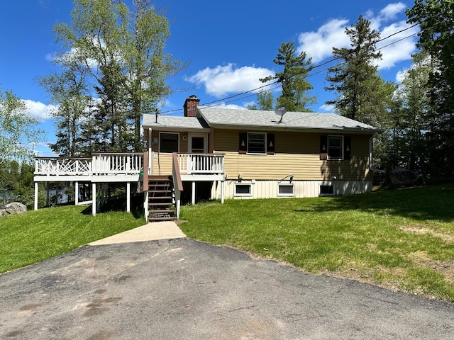 view of front of home with a wooden deck and a front lawn