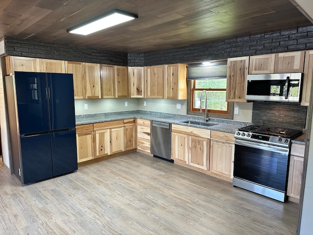 kitchen featuring light hardwood / wood-style flooring, stainless steel appliances, brick wall, and sink