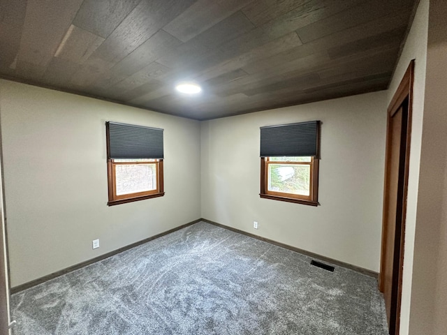 unfurnished room featuring carpet and wood ceiling