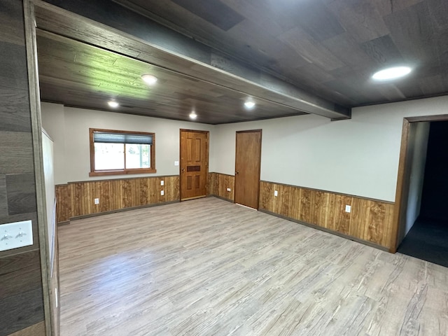 spare room with wooden walls and light wood-type flooring