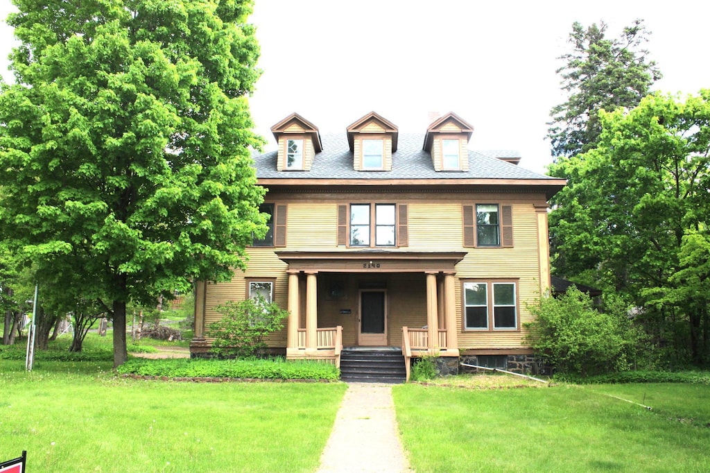 view of front of home with covered porch and a front yard