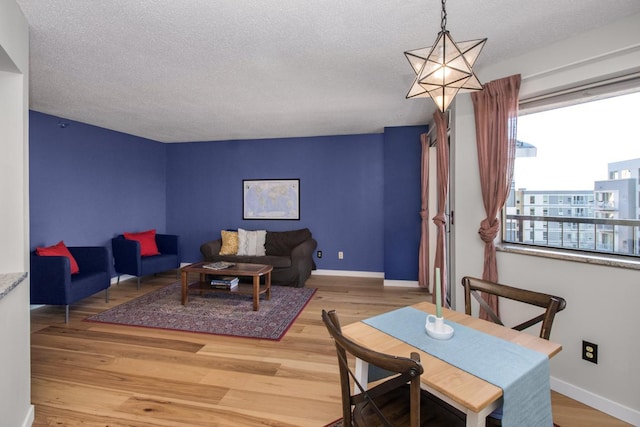 living room featuring hardwood / wood-style flooring, a textured ceiling, and a notable chandelier