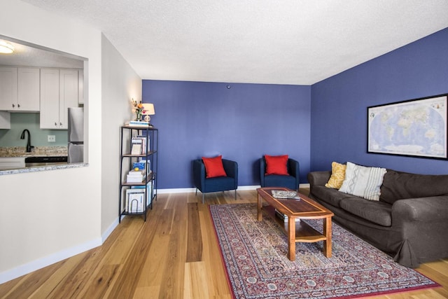 living room featuring light hardwood / wood-style flooring and a textured ceiling