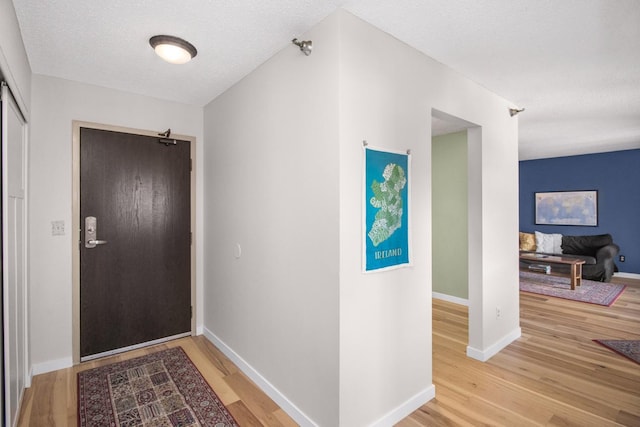 entryway with wood-type flooring and a textured ceiling