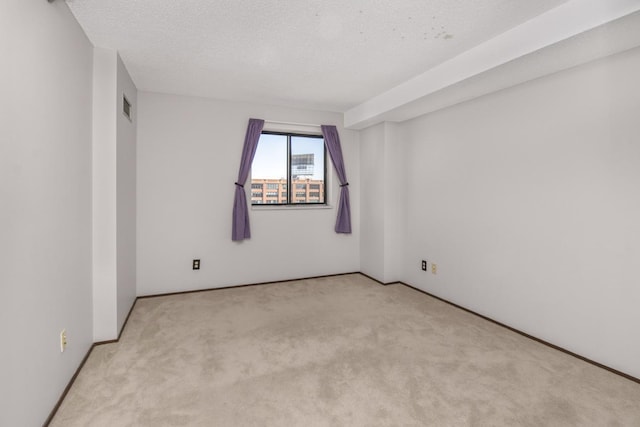 carpeted spare room featuring a textured ceiling