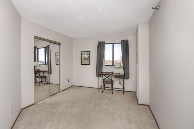 unfurnished room with a textured ceiling and light carpet