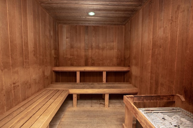 view of sauna / steam room with wood walls, hardwood / wood-style flooring, and wooden ceiling