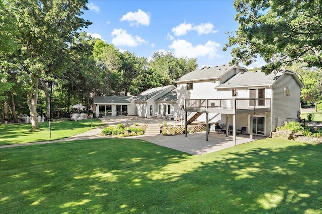 rear view of house featuring a yard, a patio area, and a deck