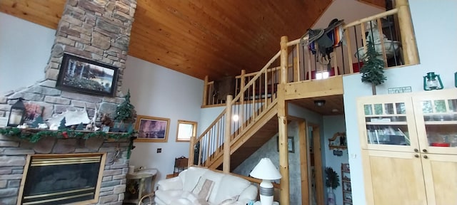 living room featuring a stone fireplace, wooden ceiling, and high vaulted ceiling