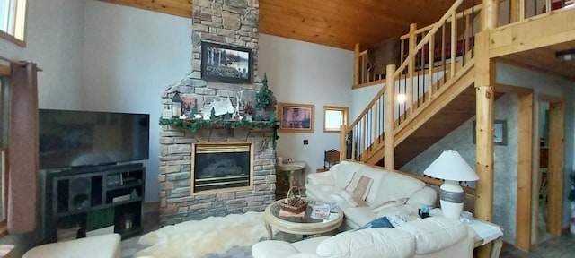 living room with a stone fireplace, a towering ceiling, and wood ceiling