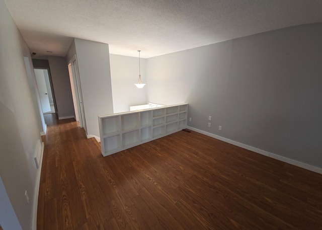 spare room with dark wood-type flooring and a textured ceiling