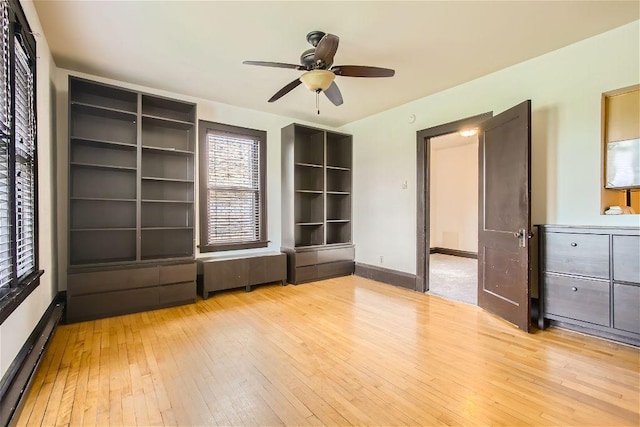 interior space with ceiling fan, light wood-type flooring, a closet, and a baseboard heating unit