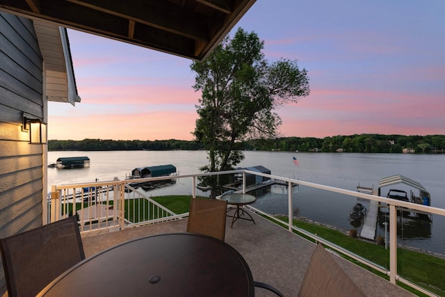 balcony featuring outdoor dining space and a water view