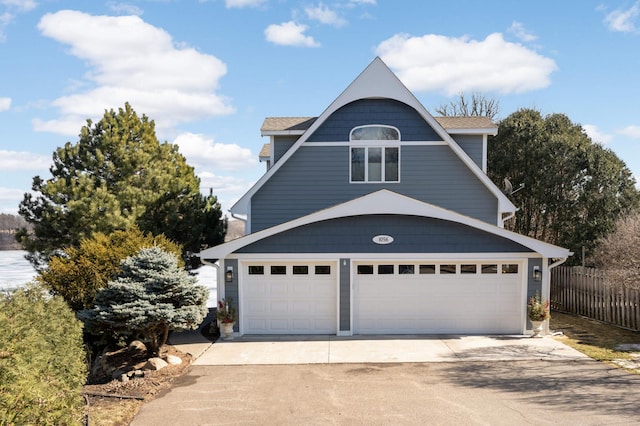 view of front of home featuring concrete driveway, fence, and an attached garage