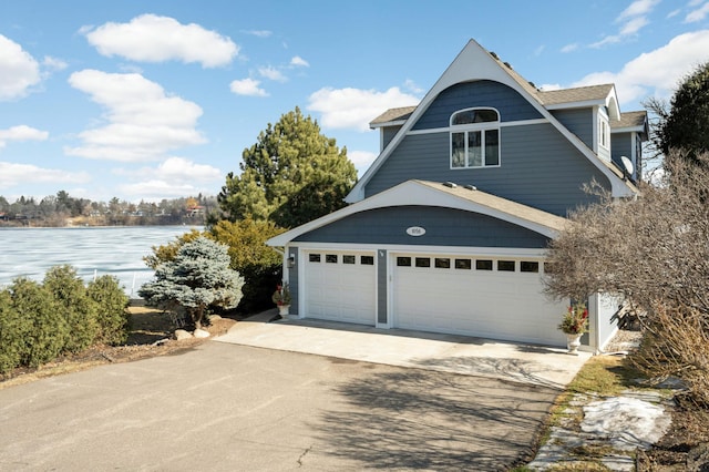 exterior space with concrete driveway and a water view