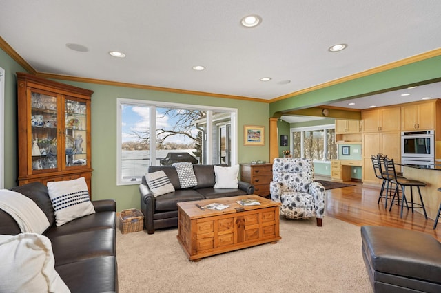 living area featuring crown molding, plenty of natural light, and recessed lighting