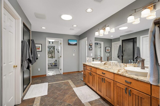 bathroom featuring double vanity, recessed lighting, a sink, and baseboards