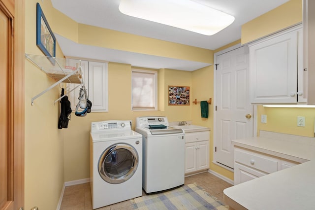 laundry room with light tile patterned flooring, washing machine and dryer, cabinet space, and baseboards