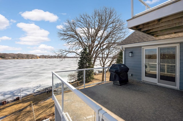 deck with grilling area and a water view