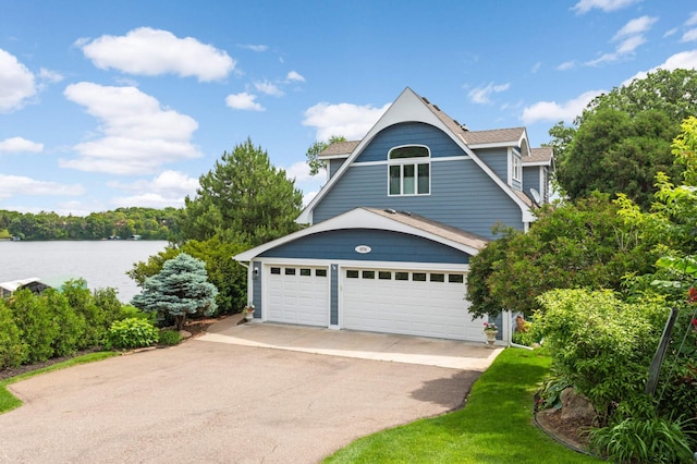 view of front of house with a water view, driveway, and roof with shingles