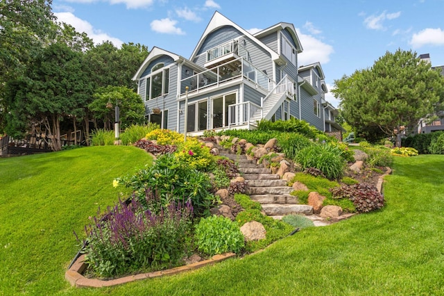 back of house with stairway and a lawn