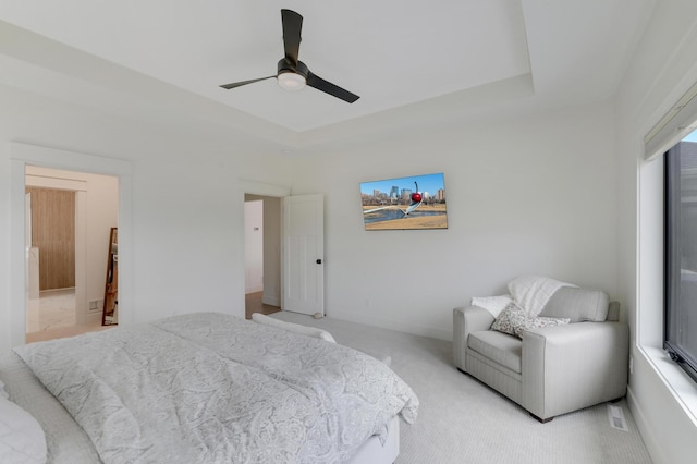 bedroom featuring ceiling fan, light carpet, and multiple windows