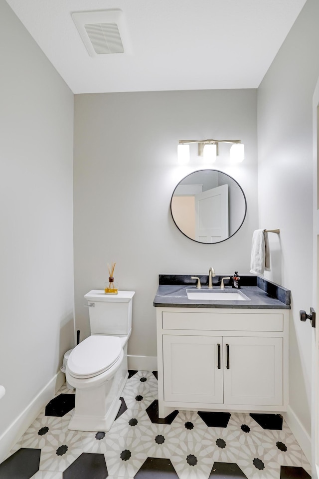 bathroom featuring tile patterned flooring, vanity, and toilet