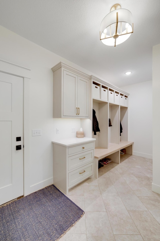 mudroom featuring light tile patterned floors and a textured ceiling