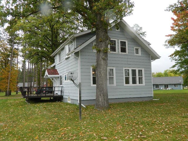 rear view of house with a deck and a lawn