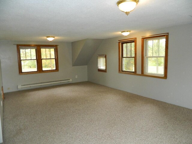 additional living space featuring a baseboard radiator, carpet floors, vaulted ceiling, and a textured ceiling