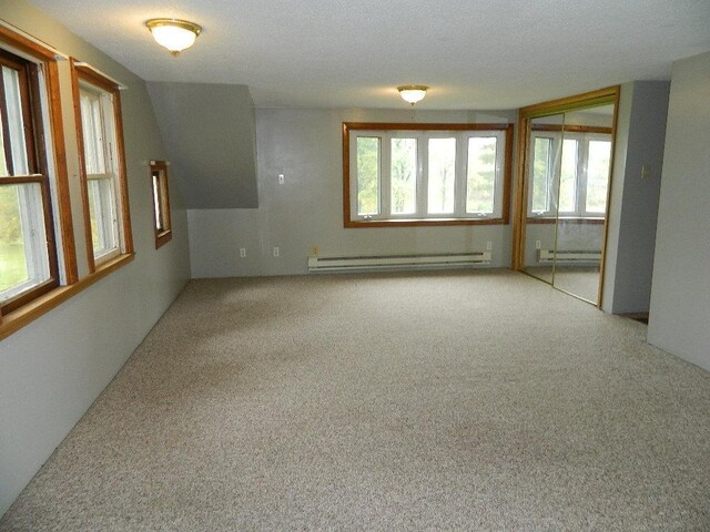 empty room featuring carpet flooring, a baseboard radiator, and a textured ceiling