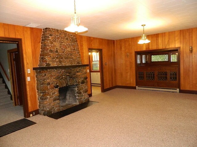 carpeted living room featuring a baseboard heating unit, wood walls, and a fireplace