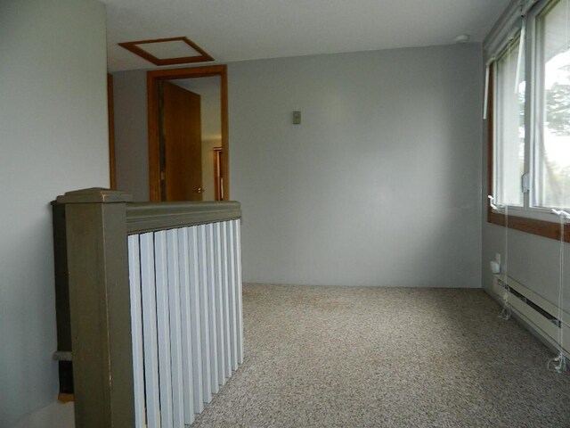 corridor featuring a baseboard heating unit and carpet flooring