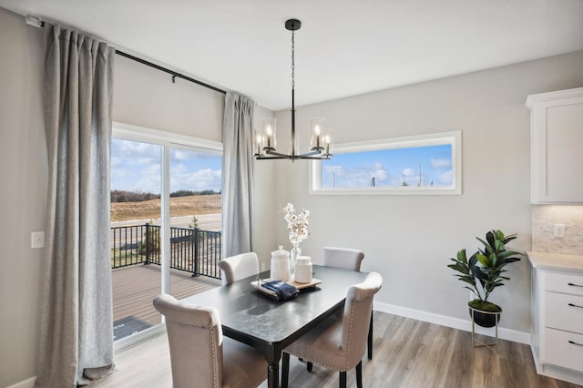 dining area with a chandelier, light wood-type flooring, and plenty of natural light