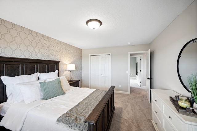 bedroom with light carpet, a textured ceiling, and a closet